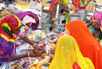 women selling bangles and other iron products in a local village market in ndia